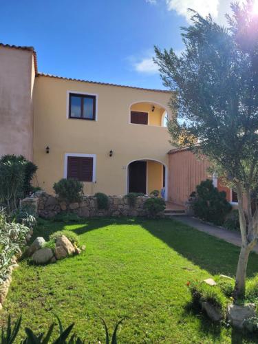 a house with a yard in front of it at Surf House Mirice in Vignola Mare