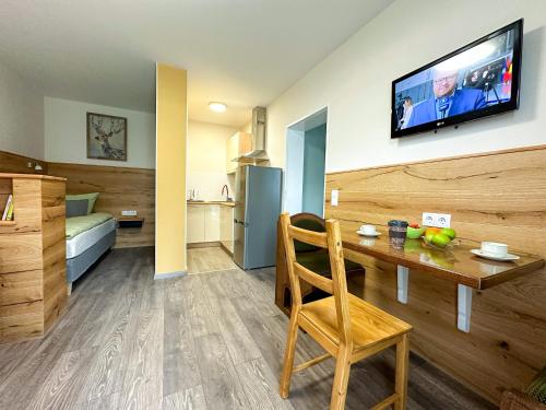 a room with a table and a television on a wall at Hotel Waldberg in Stolberg