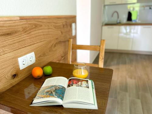 an open book on a table with a glass of orange juice at Hotel Waldberg in Stolberg