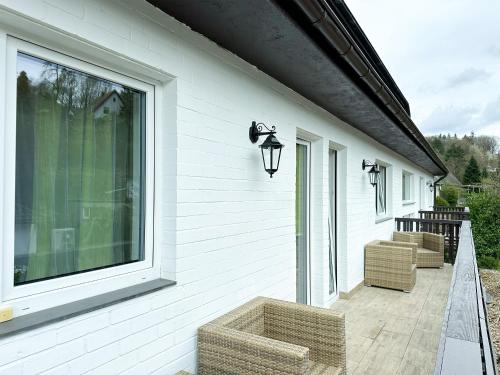 a porch with two chairs and a large window at Hotel Waldberg in Stolberg