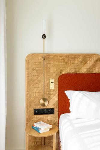 a bedroom with a bed and a table with a lamp at Le Plessis Grand Hotel in Le Plessis-Robinson