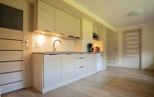 a kitchen with white cabinets and a sink at Apartament Pod Malinka in Wisła