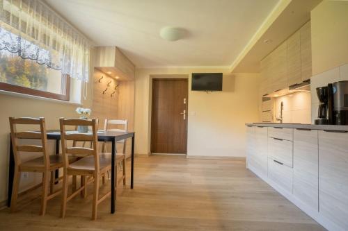 a kitchen with a table and chairs in a room at Apartament Pod Malinka in Wisła