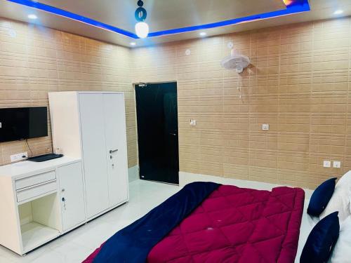 a bedroom with a bed and a desk and a wall at As Hotel Expo Inn in Greater Noida