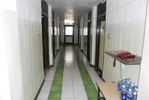 an empty hallway with a green and white tile hallway at Hotel Swagat Bhubaneswar in Bhubaneshwar