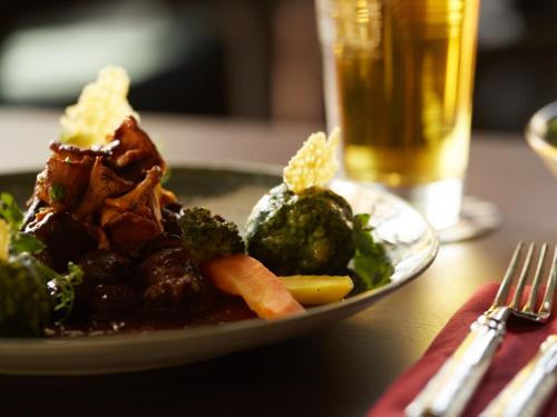 a plate of food with meat and vegetables on a table at Hotel Zum Goldenen Hirsch in Sonthofen
