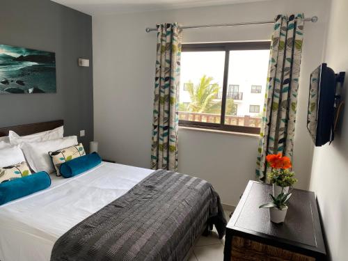 a bedroom with a large bed and a window at Salisland365 Private Apartment - Self Catering Dunas Beach Resort in Santa Maria