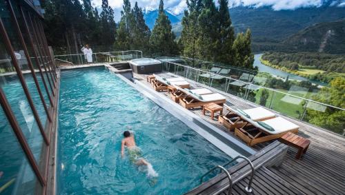 a person swimming in a swimming pool on a house at Uman Lodge Patagonia Chile in Futaleufú