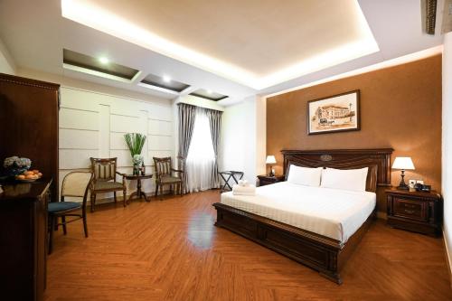 - une chambre avec un lit, une table et des chaises dans l'établissement Nicecy Hotel - Bui Thi Xuan Street, à Hô-Chi-Minh-Ville