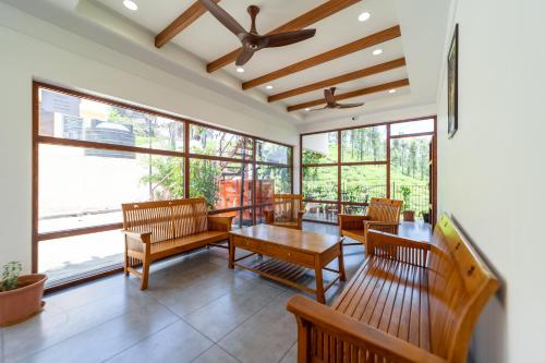 a living room with wooden furniture and large windows at WINTEL WILD in Vālpārai