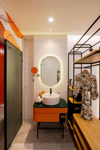 a bathroom with a sink and a mirror at PĀMA Boutique Hotel & Bistro in Da Nang