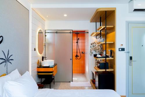 a bedroom with a bed and a bathroom with a shower at PĀMA Boutique Hotel & Bistro in Da Nang