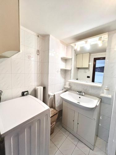 a small white bathroom with a sink and a tub at Torrione Apartment in Giovinazzo