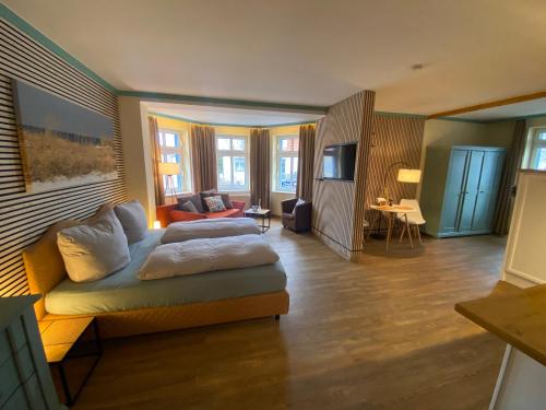 a room with a bed and a living room at Hotel von Jutrzenka in Kühlungsborn