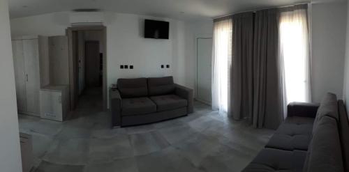 a living room with a couch and a chair at THALASSA BOUTIQUE HOTEL in Sarti