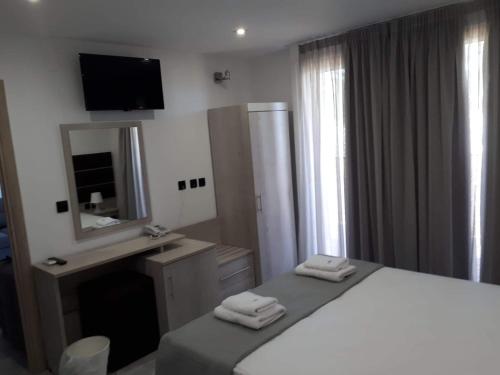 a bedroom with a large bed and a mirror at THALASSA BOUTIQUE HOTEL in Sarti