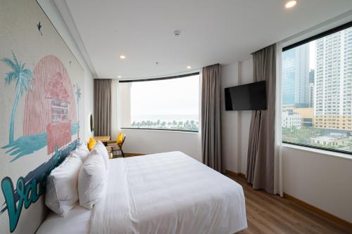 a hotel room with a large bed and a large window at PĀMA Boutique Hotel & Bistro in Da Nang