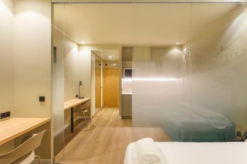 a bedroom with a glass shower and a bed at Hotel Landaben in Pamplona
