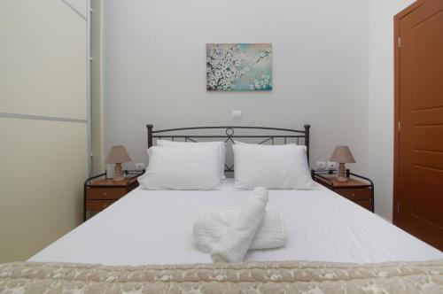 a bedroom with a white bed with two night stands at Only One in Ermoupoli