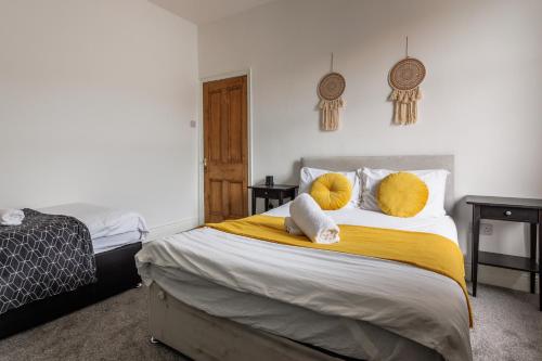 um quarto com uma cama com almofadas amarelas e brancas em Homey and Spacious 3 BR house for large group em Blythe