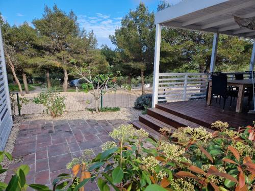 a porch with a wooden bench and a table at Mobile Homes Albatross in Jezera