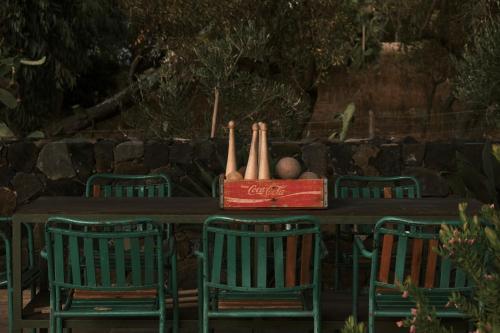 una mesa con 4 sillas y una caja de botellas de cocacola en Terra e Mare Casa Eoliana, en Quattro Pani