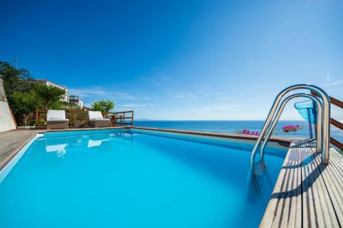 a swimming pool with a slide next to the ocean at Villa Venera - pool, jacuzzi & breathtaking view in Maiori