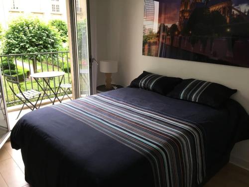 - un lit avec une couette bleue dans une chambre dans l'établissement Magnifique studio coeur Marais, à Paris