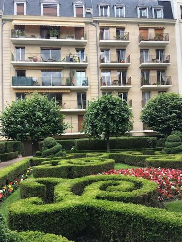 un grand bâtiment avec un jardin en face dans l'établissement Magnifique studio coeur Marais, à Paris
