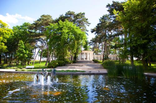 a fountain in a pond in front of a building at Küstennest in Timmendorfer Strand