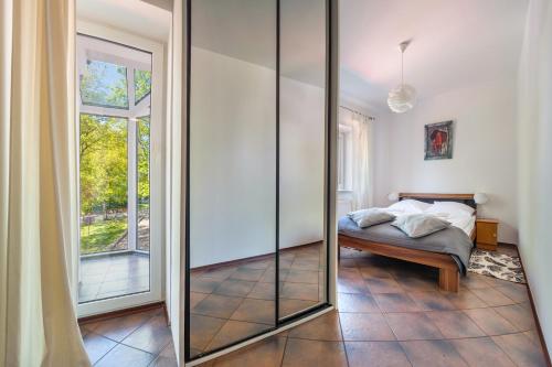 a bedroom with a glass door leading to a bed at RentPlanet - Apartament Morska in Kołobrzeg