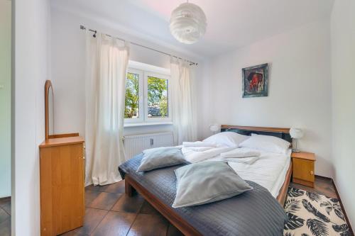 a bedroom with a bed and a window at RentPlanet - Apartament Morska in Kołobrzeg