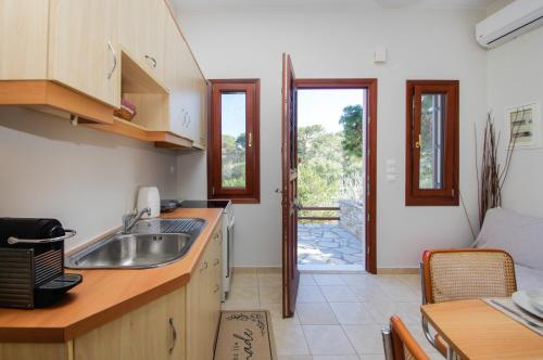 a kitchen with a sink and a door to a patio at Only One in Ermoupoli