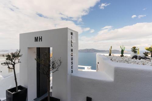 a white house with a view of the ocean at Mill Houses New Elegant Suites in Firostefani