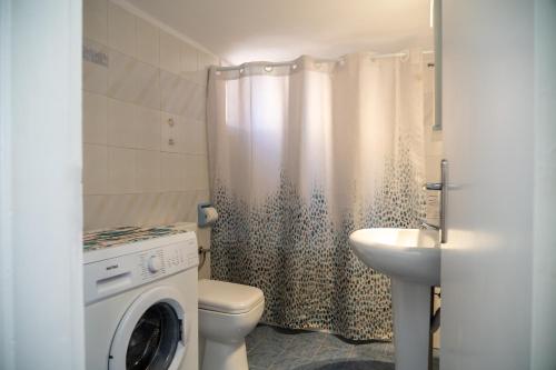 bagno con servizi igienici, lavandino e lavatrice. di Rosalia Studio Megalochori a Megalochori