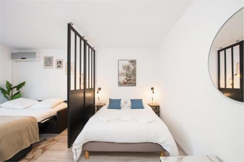 a bedroom with two beds and a mirror at 5 mn à pied Monaco - Cosy appartement - BU in Beausoleil