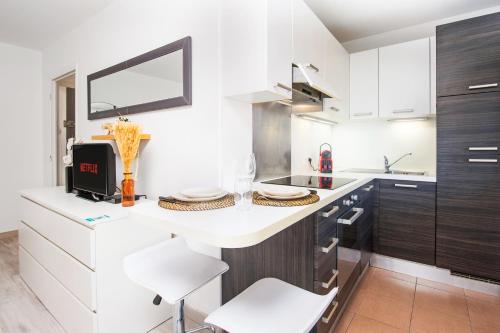 a kitchen with a white counter and white chairs at 5 mn à pied Monaco - Cosy appartement - BU in Beausoleil