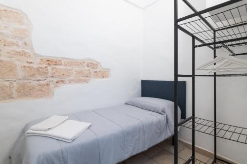 a bedroom with a bunk bed and a brick wall at White House Flats & Studios in Ostuni