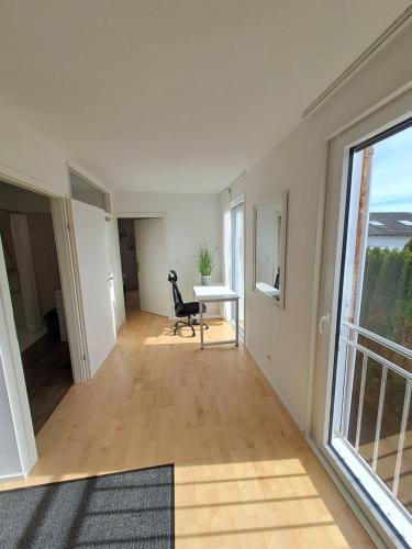an empty living room with a desk and a window at Schöne Ferienwohnung in Feldkirch