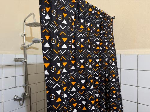 a black and orange shower curtain in a bathroom at 3 bedroom apartment on the Island/St Louis in Saint-Louis