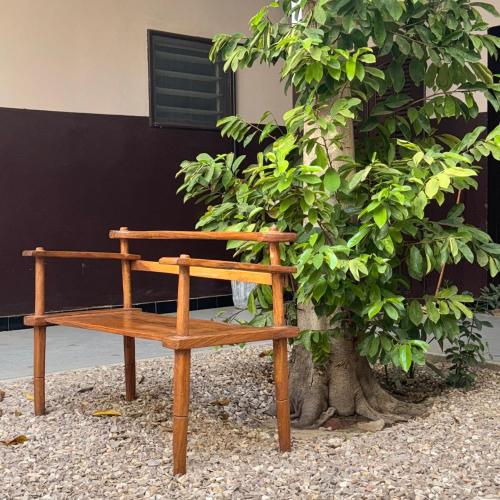 a wooden bench sitting next to a tree at 3 bedroom apartment on the Island/St Louis in Saint-Louis