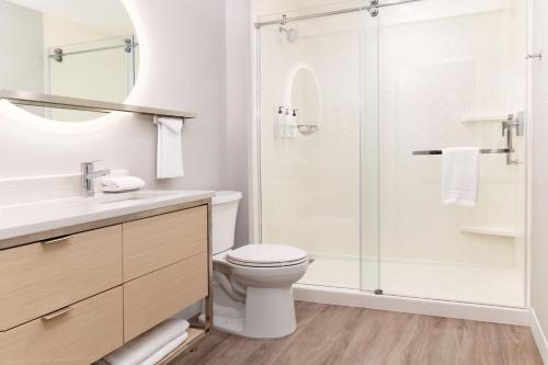 a white bathroom with a shower and a toilet at TownePlace Suites by Marriott Pleasanton in Pleasanton