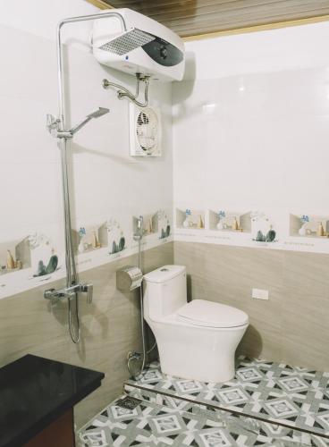 a bathroom with a white toilet and a shower at Trang An Mountain House in Ninh Binh