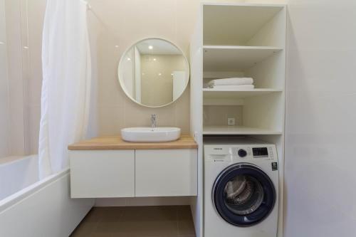 a bathroom with a washing machine and a mirror at DayFlat Apartments Maidan Area in Kyiv