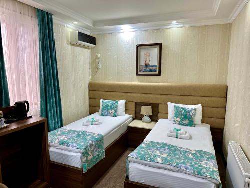 a hotel room with two beds and a television at Hotel Park in Batumi