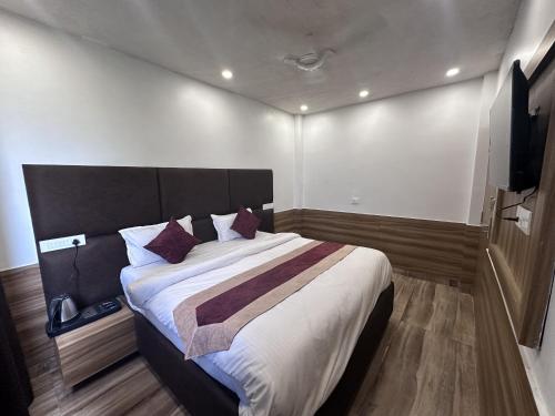 a bedroom with a large bed and a flat screen tv at Hotel Obsidian Red in Gorakhpur