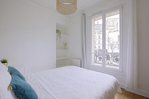 une chambre blanche avec un lit et une fenêtre dans l'établissement Luxury in the so chic 16th district, à Paris