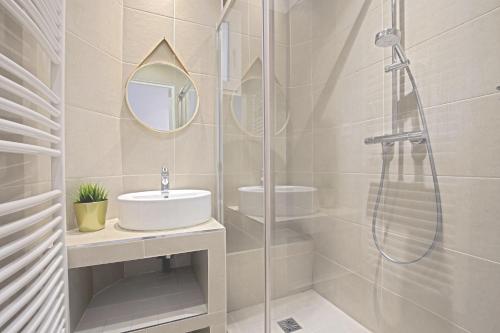 une salle de bain avec une douche en verre et un lavabo dans l'établissement Luxury in the so chic 16th district, à Paris
