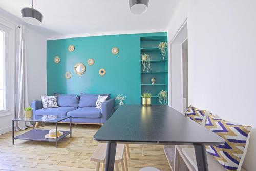 un salon avec un canapé bleu et une table dans l'établissement Luxury in the so chic 16th district, à Paris
