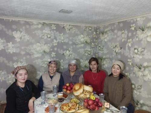 a group of people sitting at a table with food at Kush in Kochkor